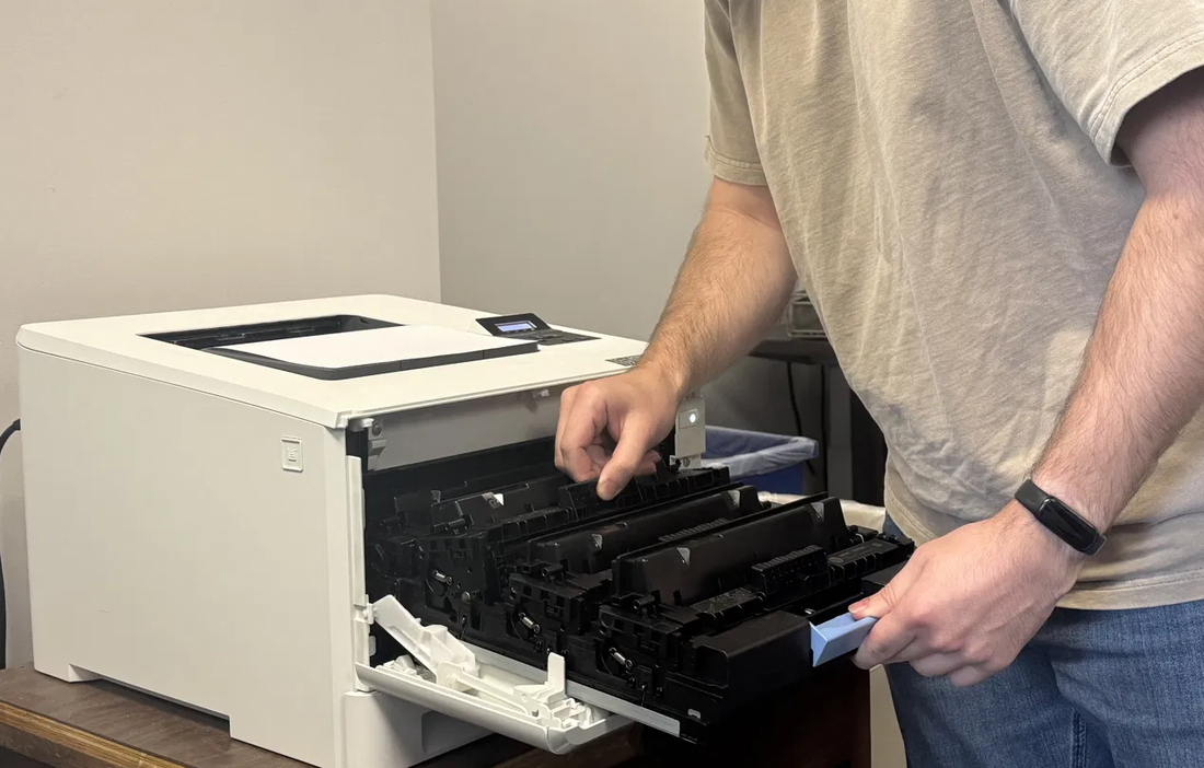 A Deskside technician replacing the toner cartridges in a customer's printer.